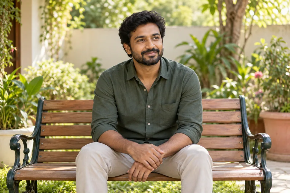 தோட்ட இருக்கையில் அமர்ந்து சுற்றுப்புறத்தைப் பார்க்கும் ஒருவர்.